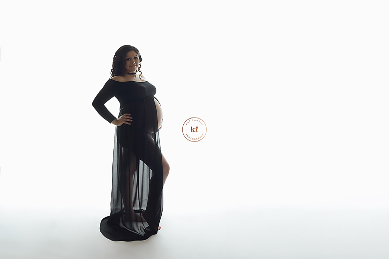 backlit_maternity_clio_pregnant_woman_in_black_dress_smiling_photographer_studio-1